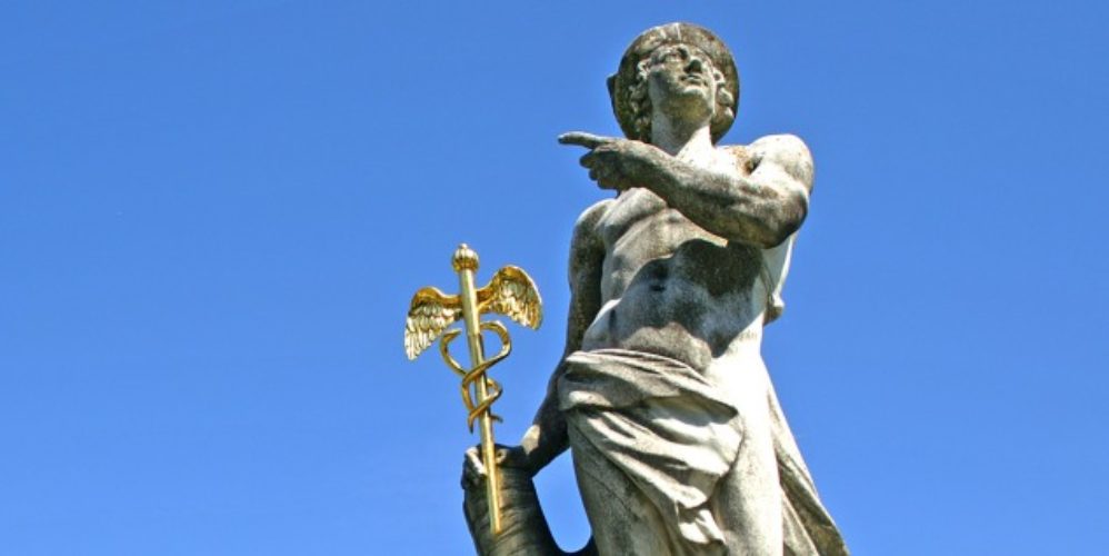 Eine Statur hält ein goldenen Äskulapstab.