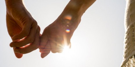 Couple Hands Holding Together with Sun Rays