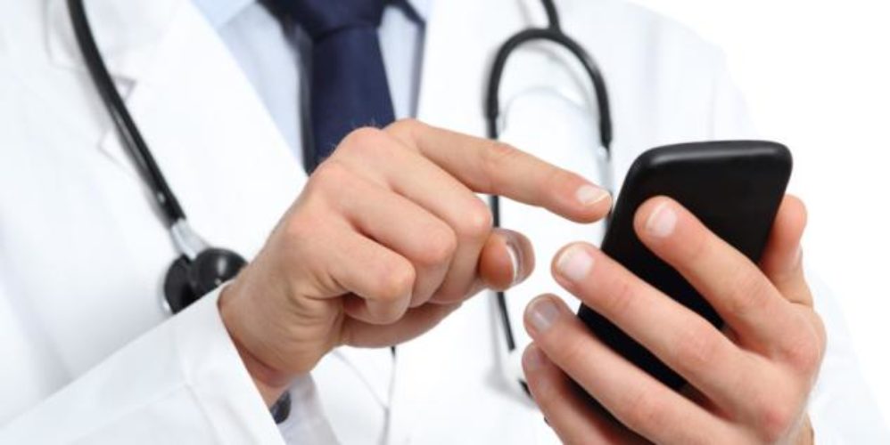 Ein Arzt benutzt die GesundheitsApp auf seinem Smartphone.