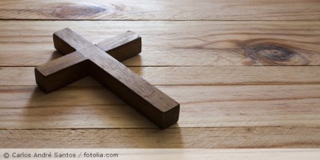 Braune Kreuzkette liegt auf einem Holztisch.
