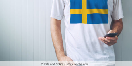 Mann im Schweden-T-Shirt bedient sein Handy