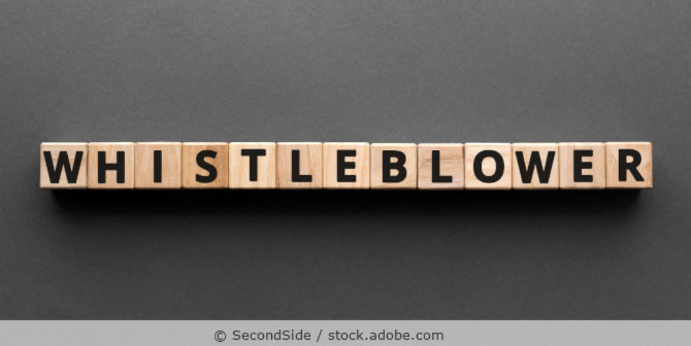 Das Wort Whistleblower gelegt aus Buchstabenwürfeln