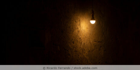 Eine Glühbirne leuchtet in einem dunklen Raum.