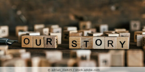 Tisch auf dem viele Holzwürfel mit Buchstaben liegen und aus Holzwürfeln sind die Worte "our story" gelegt.