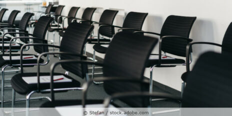 Schwanze Bürostühle stehen in Reihen in einem Konferenzraum.