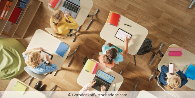 Schüler arbeiten im Klassenzimmer mit Laptops und Tablets.